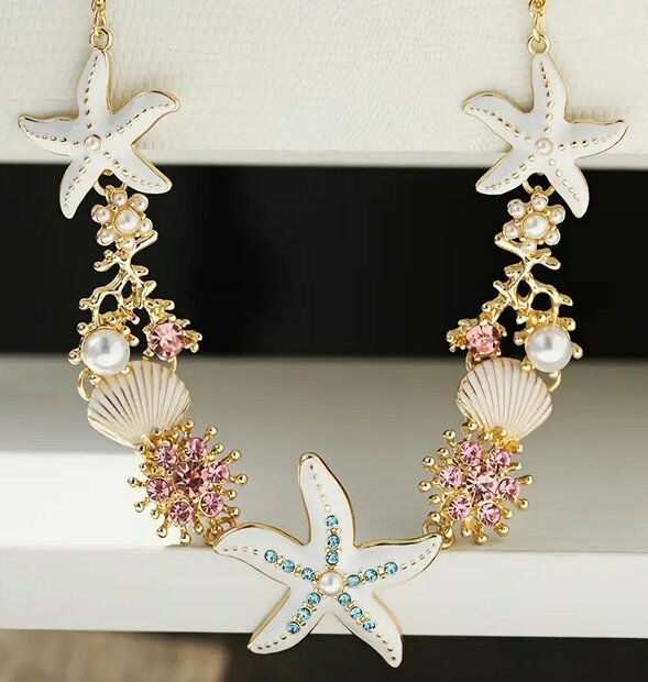 Goudkleurige ketting met wit gekleurde Bedels